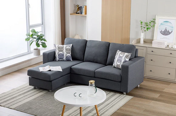 My Furniture modern dark gray fabric sectional sofa with chaise lounge and patterned accent pillows, styled in a bright living room.